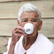 An elderly man sitting and drinking coffee