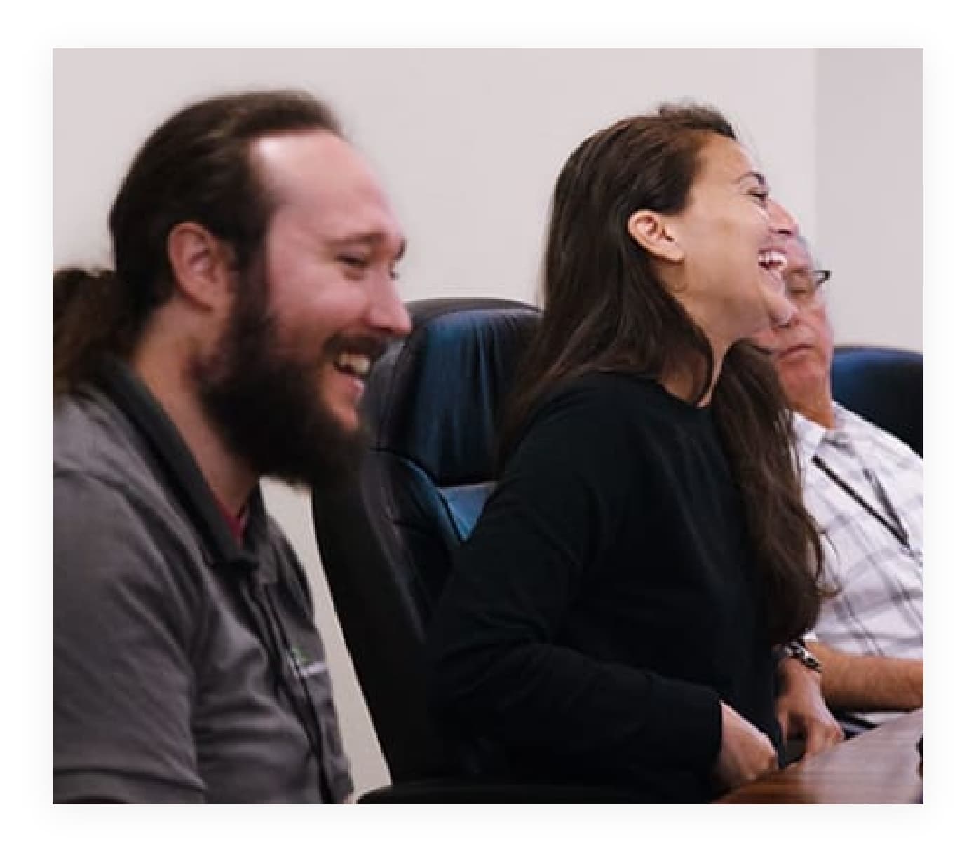 Three Advanced Diabetes Supply employees smiling while sitting a conference table