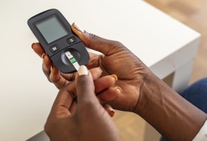 A woman holding blood glucose testing equipment