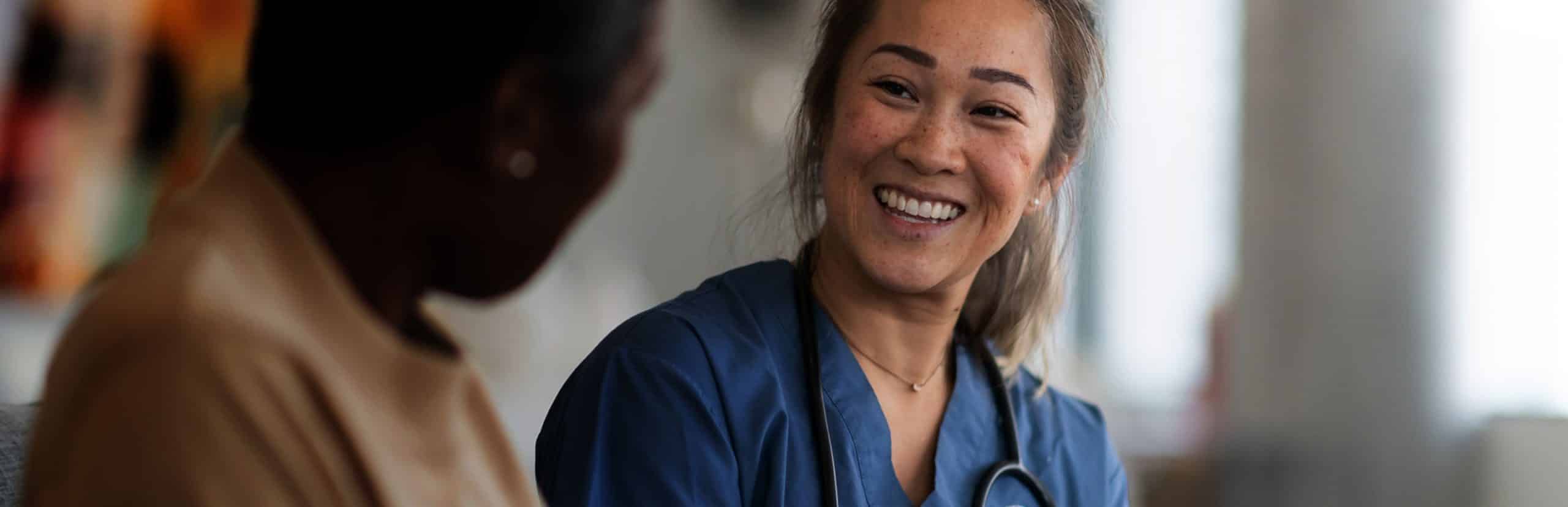 A female doctor talking to a female patient and smiling