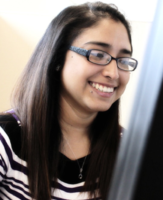 Woman smiling while looking at her computer