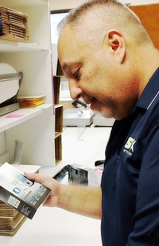 Man looking at a box for a glucose meter