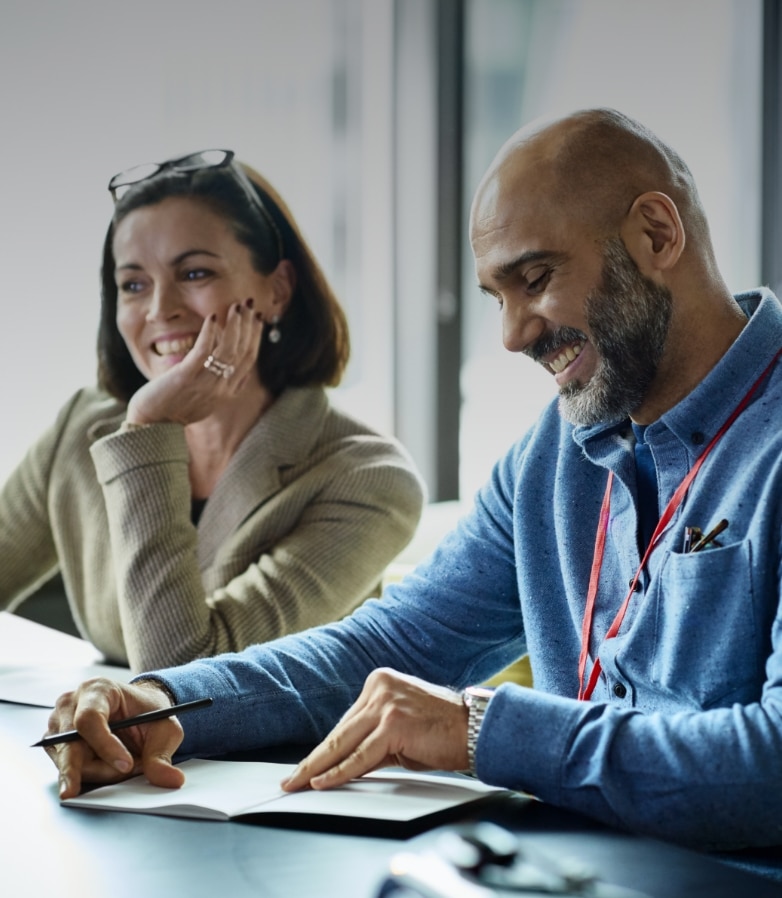 Three professionals sitting at a conference table in an office