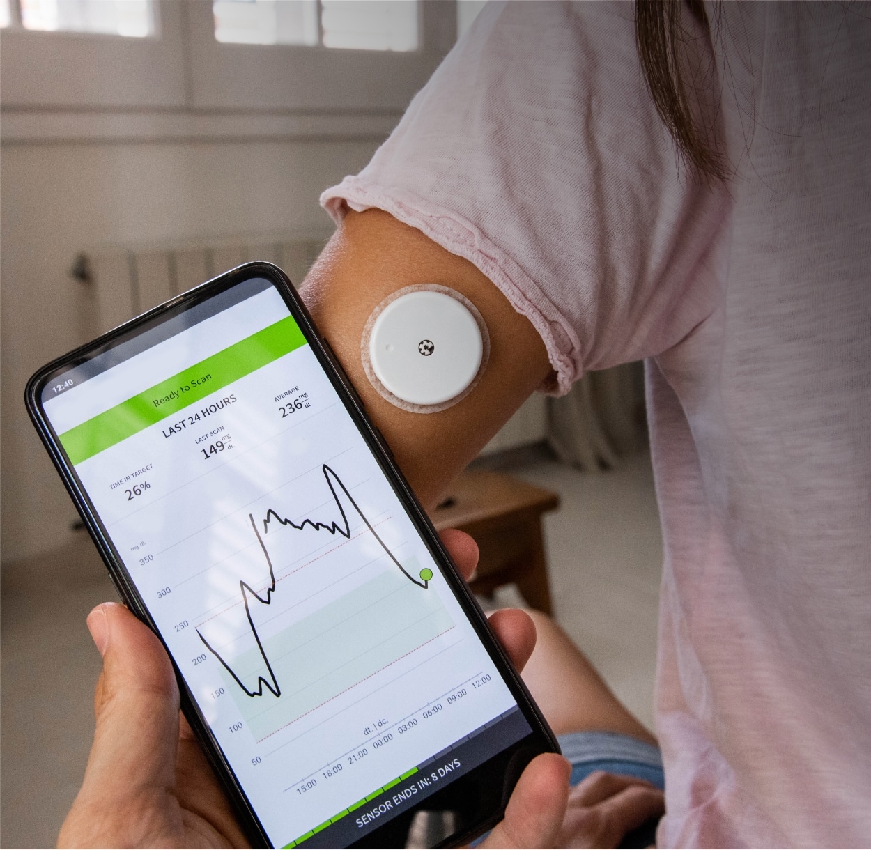 A closeup photo of a woman's arm while she using a continuous glucose monitor