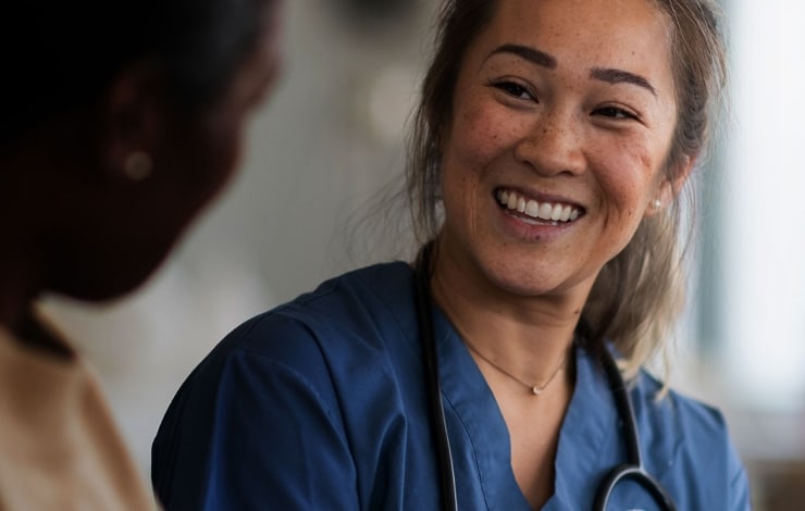 A female doctor talking to a female patient and smiling