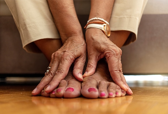 woman touching her feet to represent diabetes care