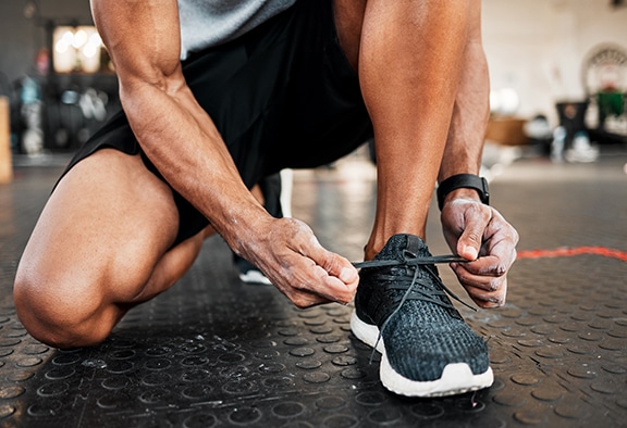 Shot of a man tying his laces before a workout