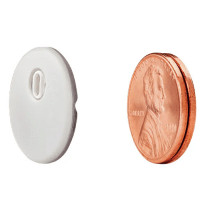 The Abbott Freestyle Libre 3 Sensor is shown next to two stacked pennies.