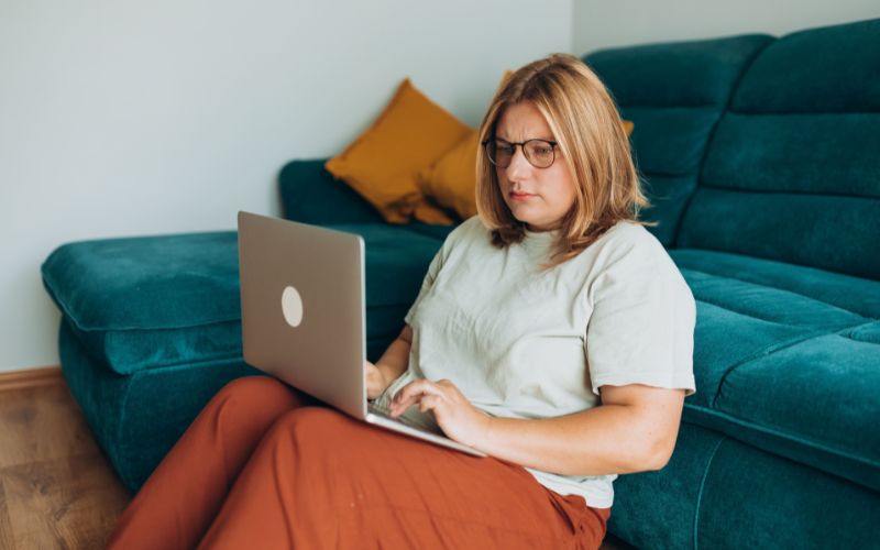 A concerned woman sits on her laptop researching the connection between stress and diabetes.
